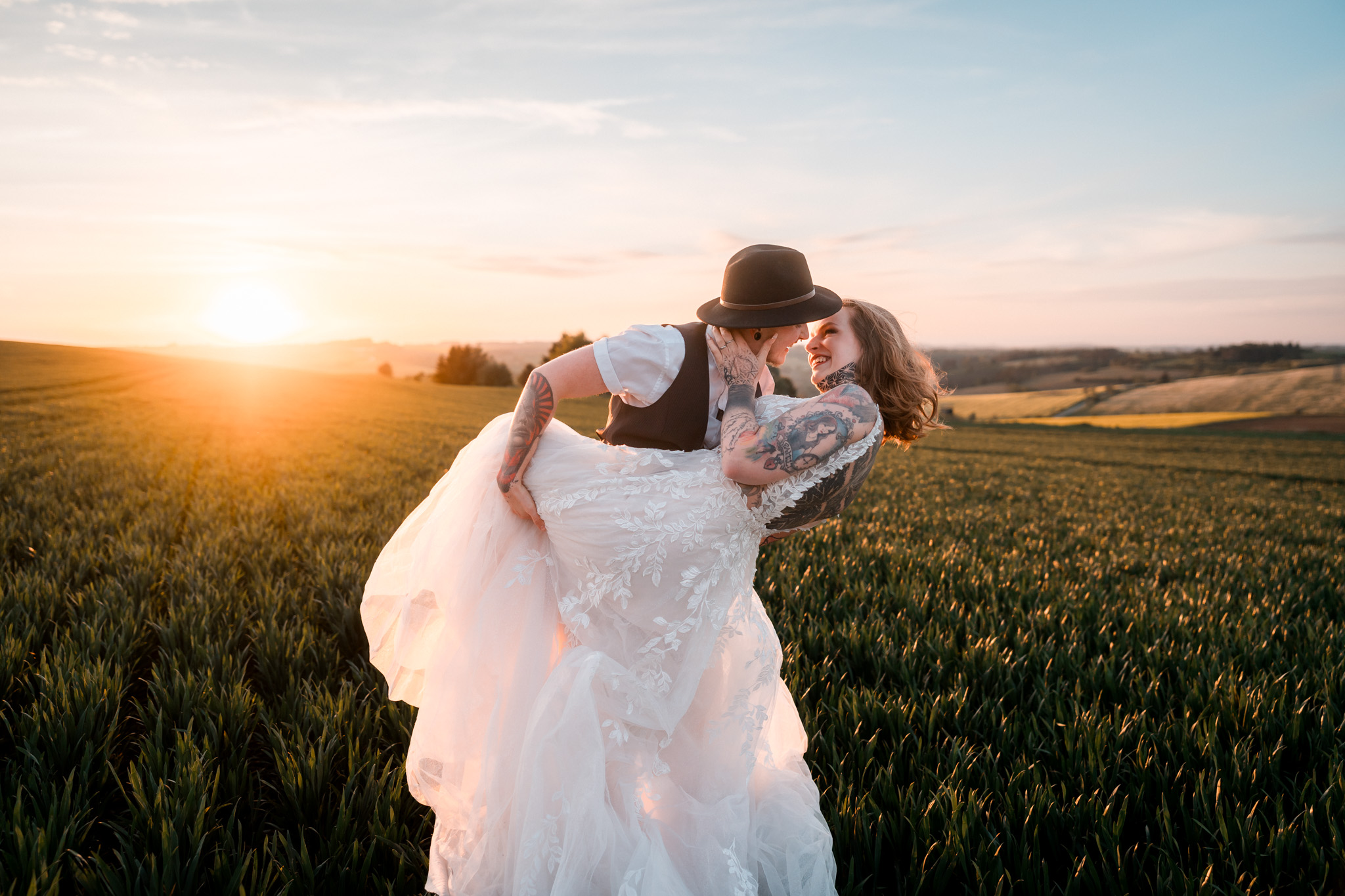 Nevěsta a ženich ve svatebních šatech na louce při západu slunce, Za vratama, Bransouze, 2024