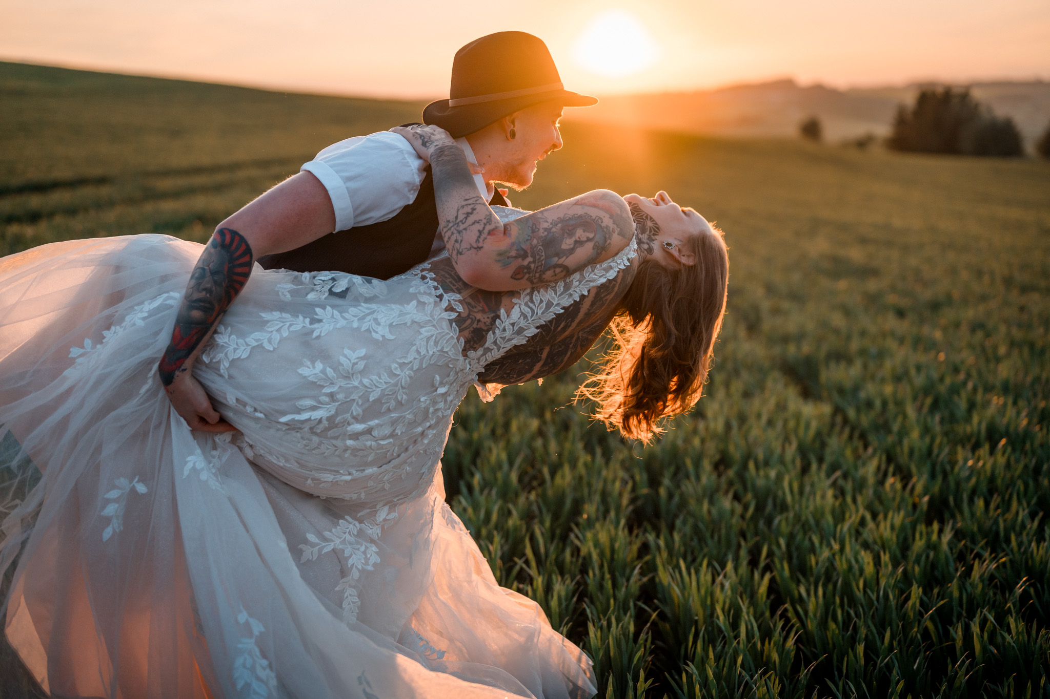 Ženich a nevěsta ve svatebních šatech na louce při západu slunce, Za vratama, Bransouze, 2024